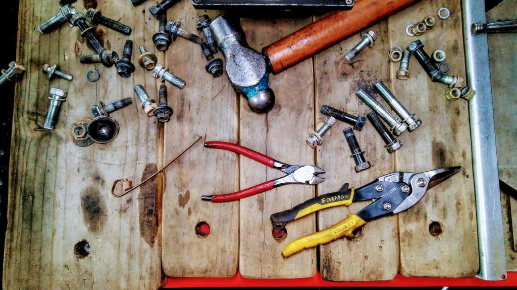 An array of tools and bolts used in repair set on an old wooden bench.