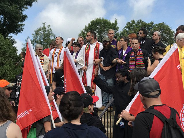 Clergy at the stairs to Emancipation Park, resisting the “Unite the Right” rally in Charlottesville. Photo by Anthony Crider. Some rights reserved. Flickr.com 