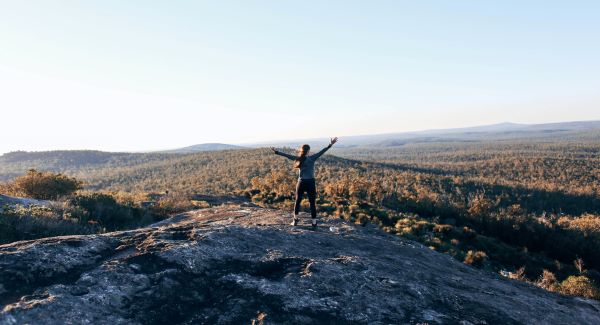 woman on top of mountain, arms raised
