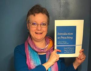 Rev. Dr. Leah Schade holding book Introduction to Preaching