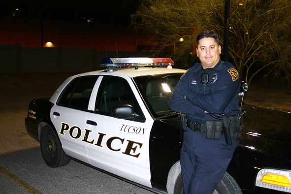 A police officer with his patrol car. Obtained through Creative Commons. 