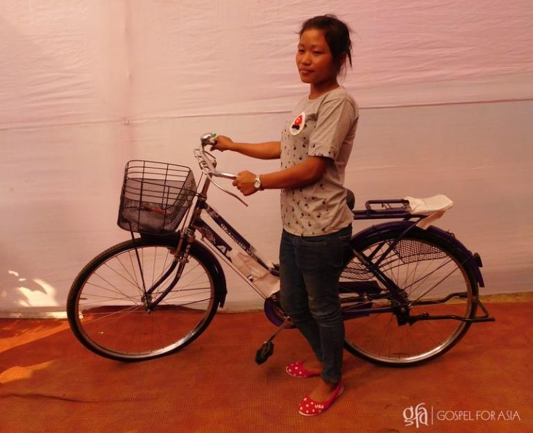 Sudipti stands beside her new gift: a bicycle! - KP Yohannan - Gospel for Asia