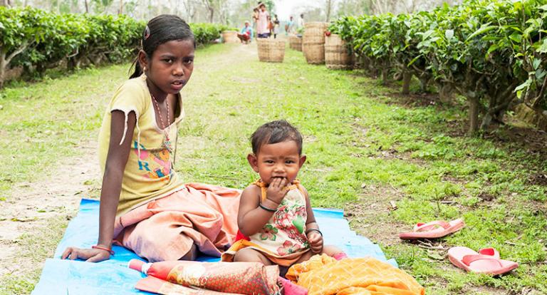 This girl takes care of her younger sister while her mother works at a tea plantation - KP Yohannan - Gospel for Asia