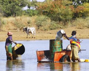  women are collecting water for crop irrigation in Burkina Faso - KP Yohannan - Gospel for Asia