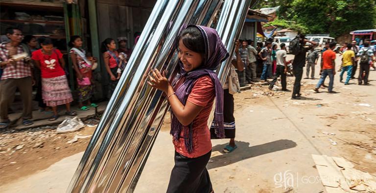 By God's grace, like this woman pictured, Kata was given tin sheets to help provide for her needs through a GFA-supported gift distribution.