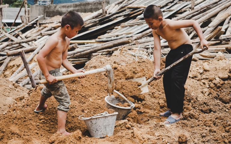 These young boys, deprived of their childhood and forced into child labor, are working hard on a commercial building structure.