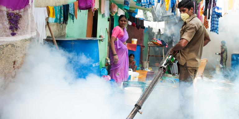 Gospel for Asia founded by Dr. KP Yohannan: The government working is spraying mosquito repelling smoke in a Mumbai slum to prevent malaria and other mosquito-spread diseases.