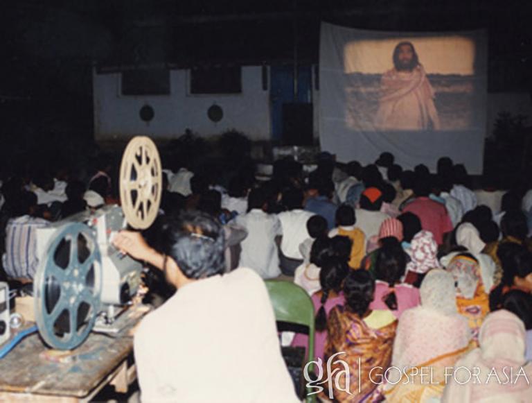 Like those in this photo, villagers sat enraptured watching the films Deepak shared about Jesus.