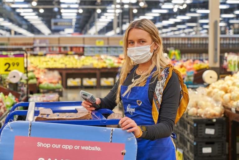 Korger woman employee attending produce section