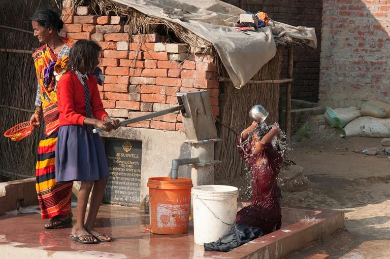 Little girls taking a bath using clean water from Jesus Wells.
