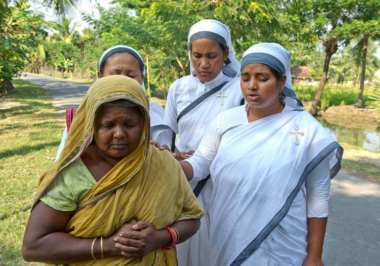 Sisters of Compassion pray for a desperate widow