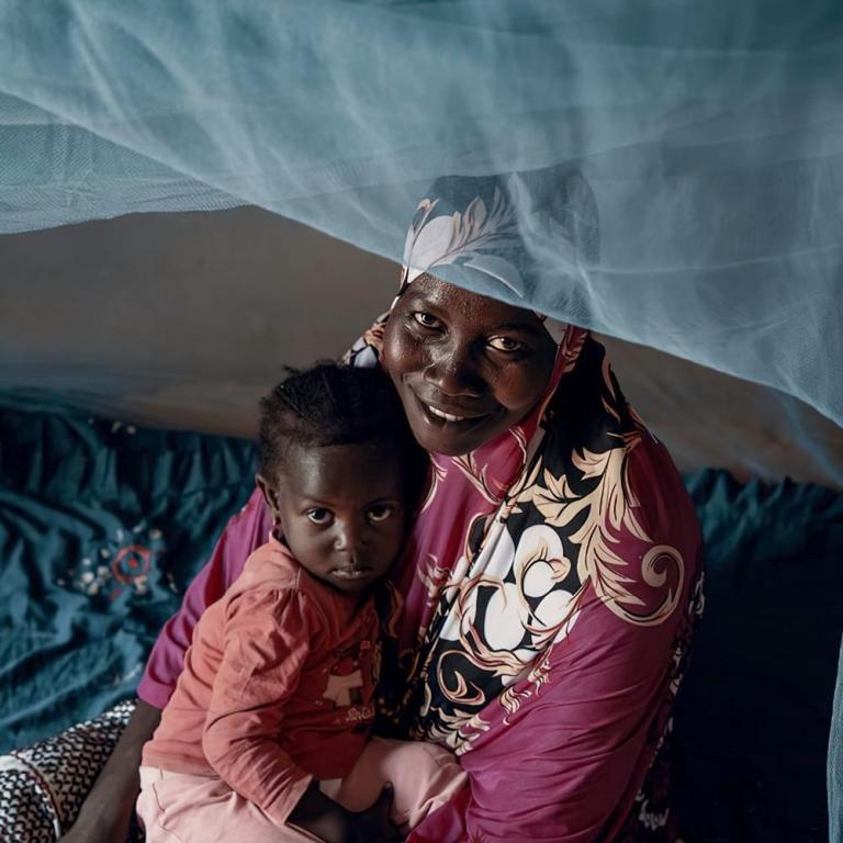 Mother and child under mosquito net