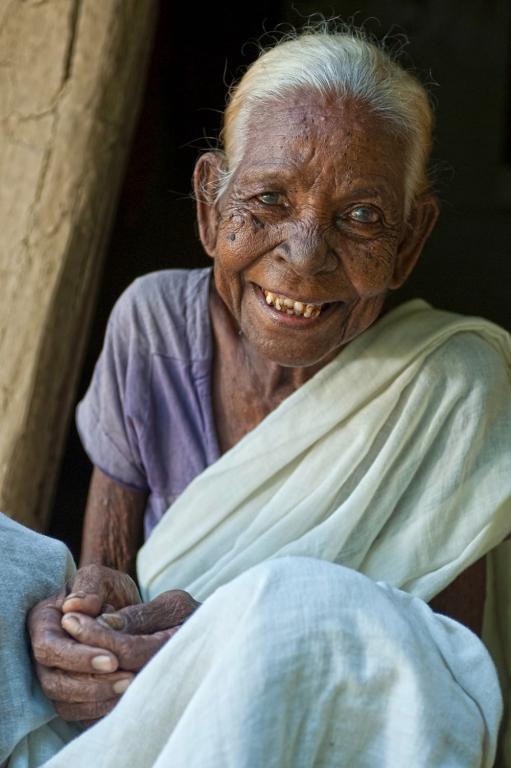 Smiling widow despite isolation and suffering.