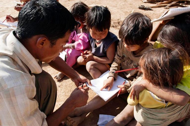 A national missionary worker teaches a group of children how to read