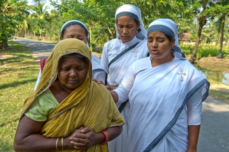 Sisters of Compassion, women national missionary workers, praying for a poor widow
