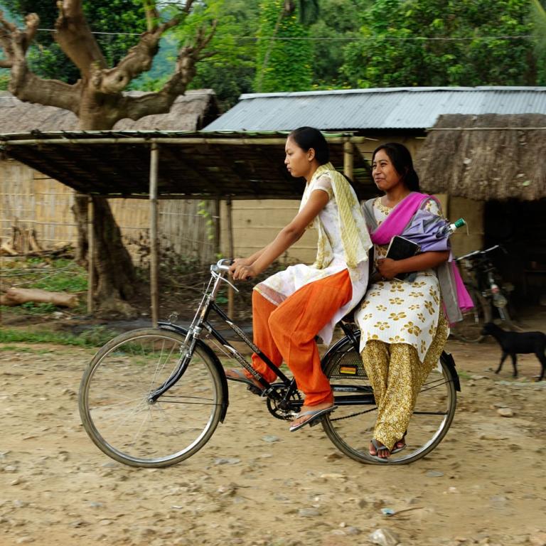 Women national missionary workers travel from one village to another with the use of a bicycle