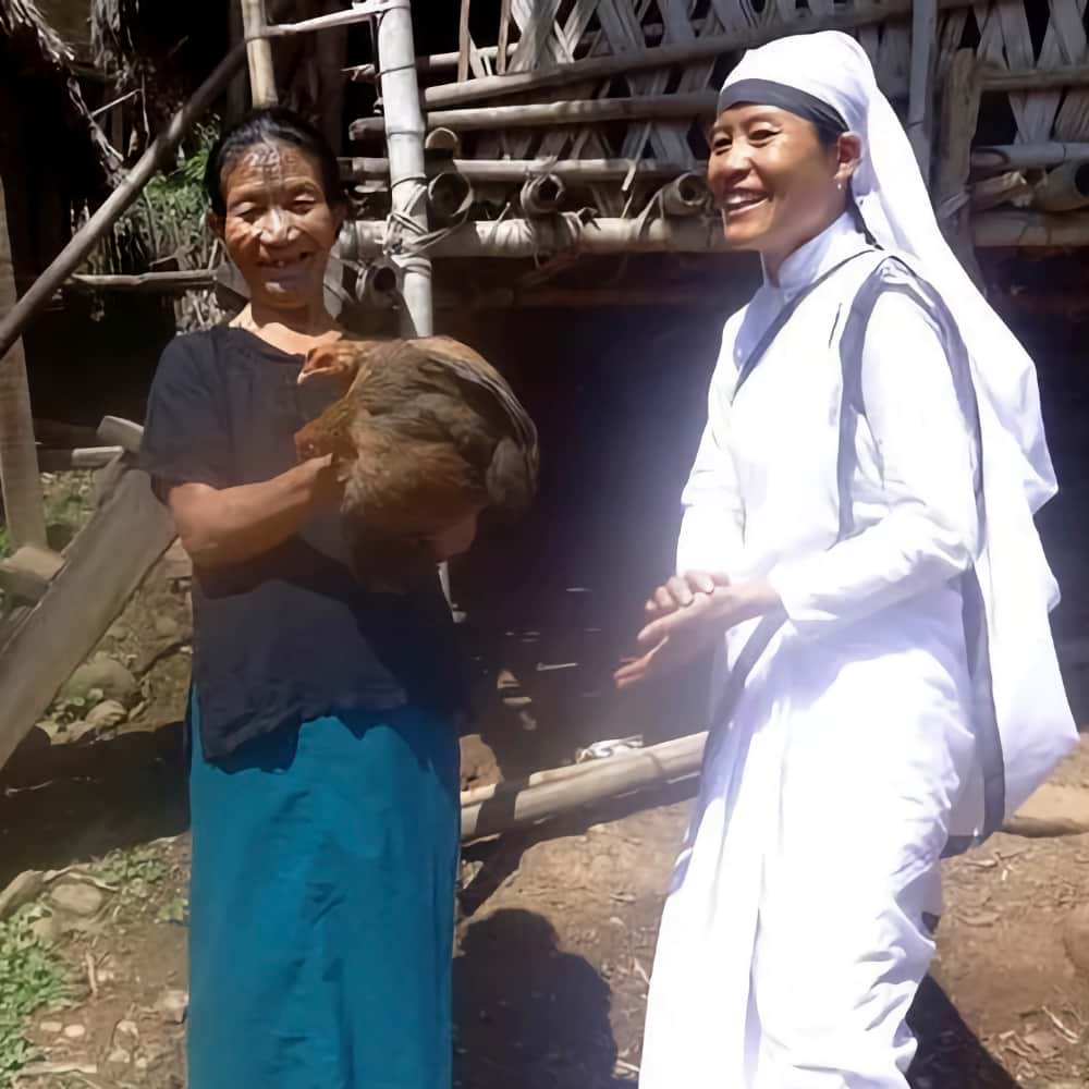 Mayra receives a pair of chickens from GFA World Sisters of Compassion