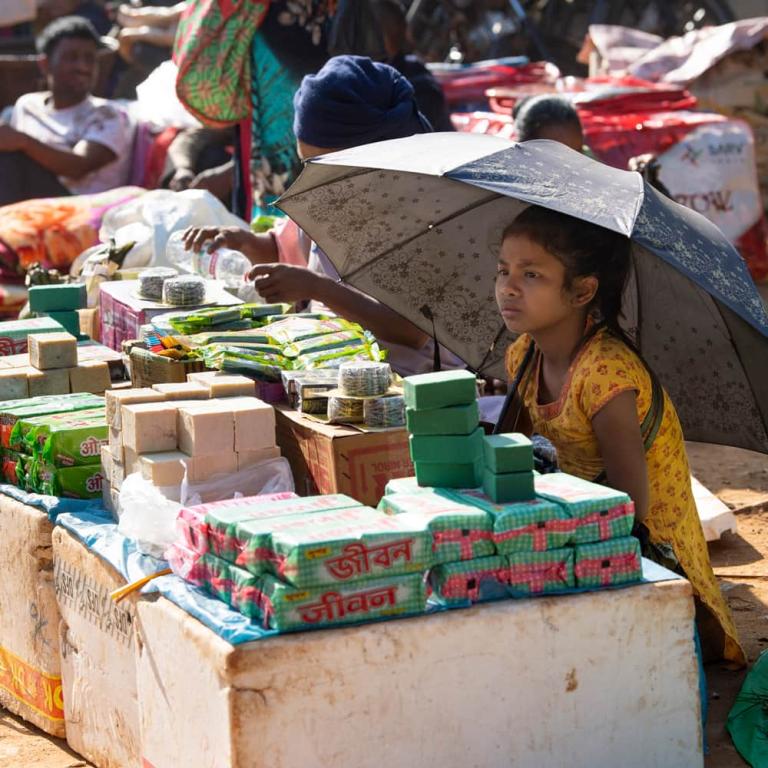 Little girl selling vegetables in the weekly market