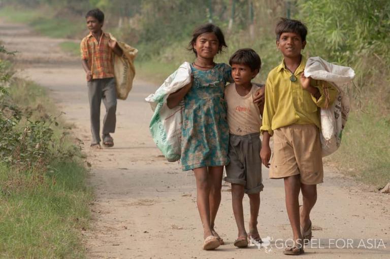 Poor children in Asia walking along the street