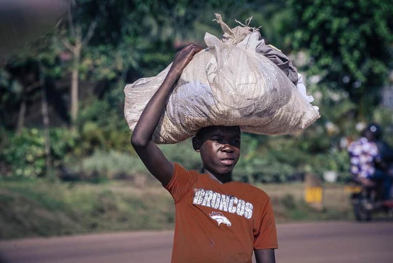 Young boy from Africa collecting garbage to help earn some money for his family
