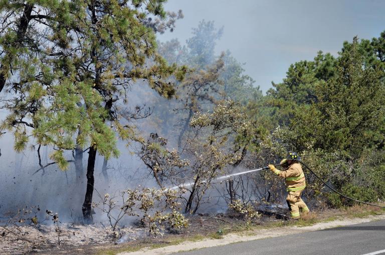 Firefighters from the 106th Rescue Wing assist with extinguishing a brush fire in Westhampton, N.Y., on Aug. 10, 2015. Altogether, eight brush trucks, seven tankers and 14 different fire departments worked together to battle the blaze which destroyed four acres of land along the west side of Old Riverhead Road. (New York Air National Guard/Staff Sgt. Christopher S Muncy)