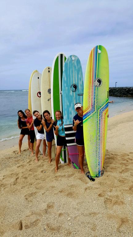 women holding surfboards at the beach