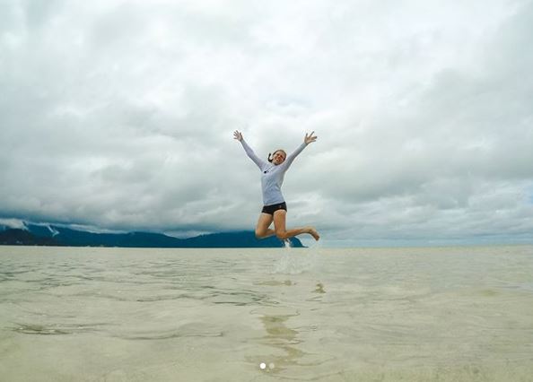 Woman jumping above water