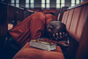 Man praying in a church pew invocation and benediction