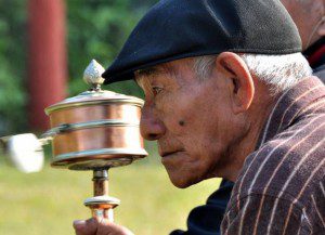 Tibetan man with a prayer wheel, Bodhgaya, India