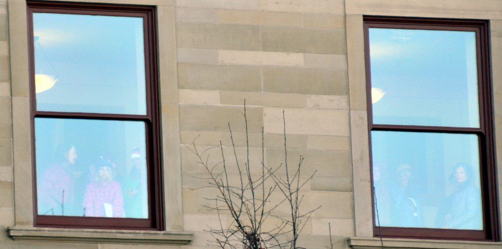 (women and a girl watching from inside the Capitol)