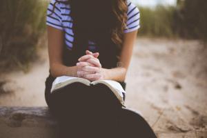 woman-black-white-stripe-t-shirt-book-her-lap-sitting-sand-daytime-82951113