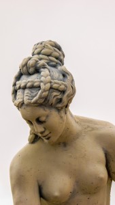 statue of aphrodite with her hair in a complex braided form