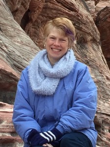headshot, wearing blue coat and fuzzy light blue scarf, taken outside in Red Rock Canyon