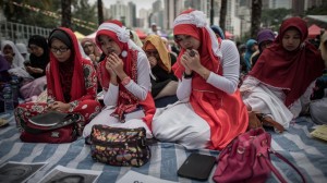 Indonesian migrant workers hold a prayer vigil in Hong Kong for the two women brutally murdered, whose bodies were found earlier this month. Image by Philippe Lopez/AFP 