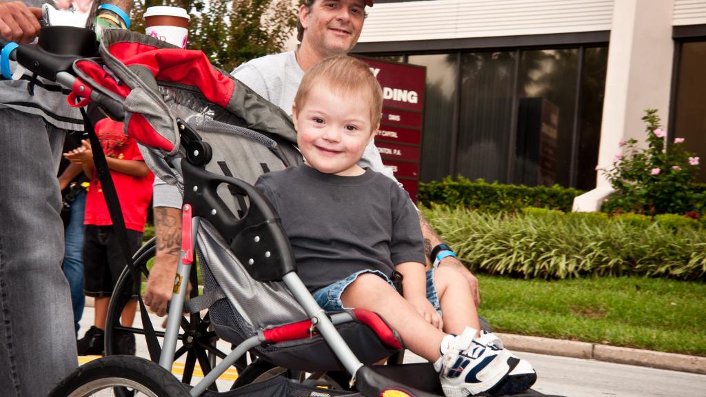Happy boy with Down syndrome in stroller