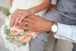 A couple holding hands dressed in wedding clothes