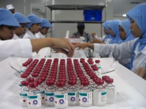 Lab workers in the Bandung BioFarma facility in Indonesia examine vaccine vials