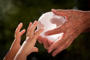 A chrystal glob passing from an old woman's hands to those of a child.