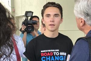Foto of David Hogg being videoed while talking with an older person.