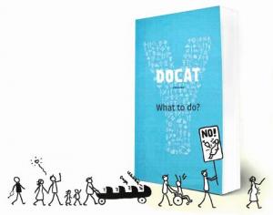 The book, DOCAT, stands next to a protest parade of stick figures.