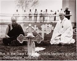 The Dalai Lama kneels before the cross marking Thomas Merton's grave.