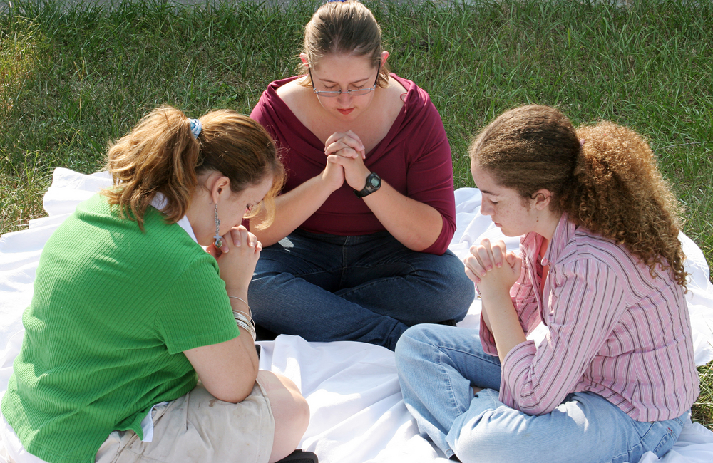 A group of teen girls gathered for prayer.